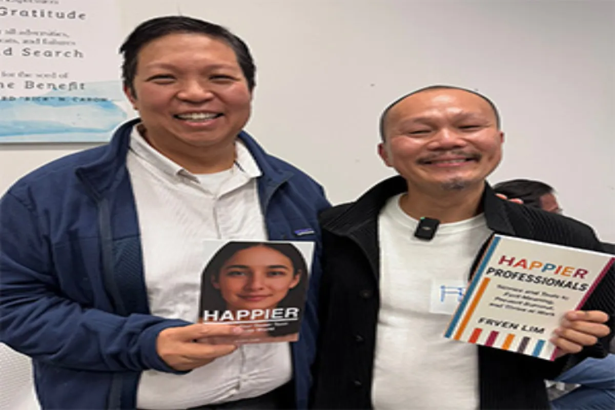 Frven with workshop participant Leonard holding Happier Professionals books after successful session