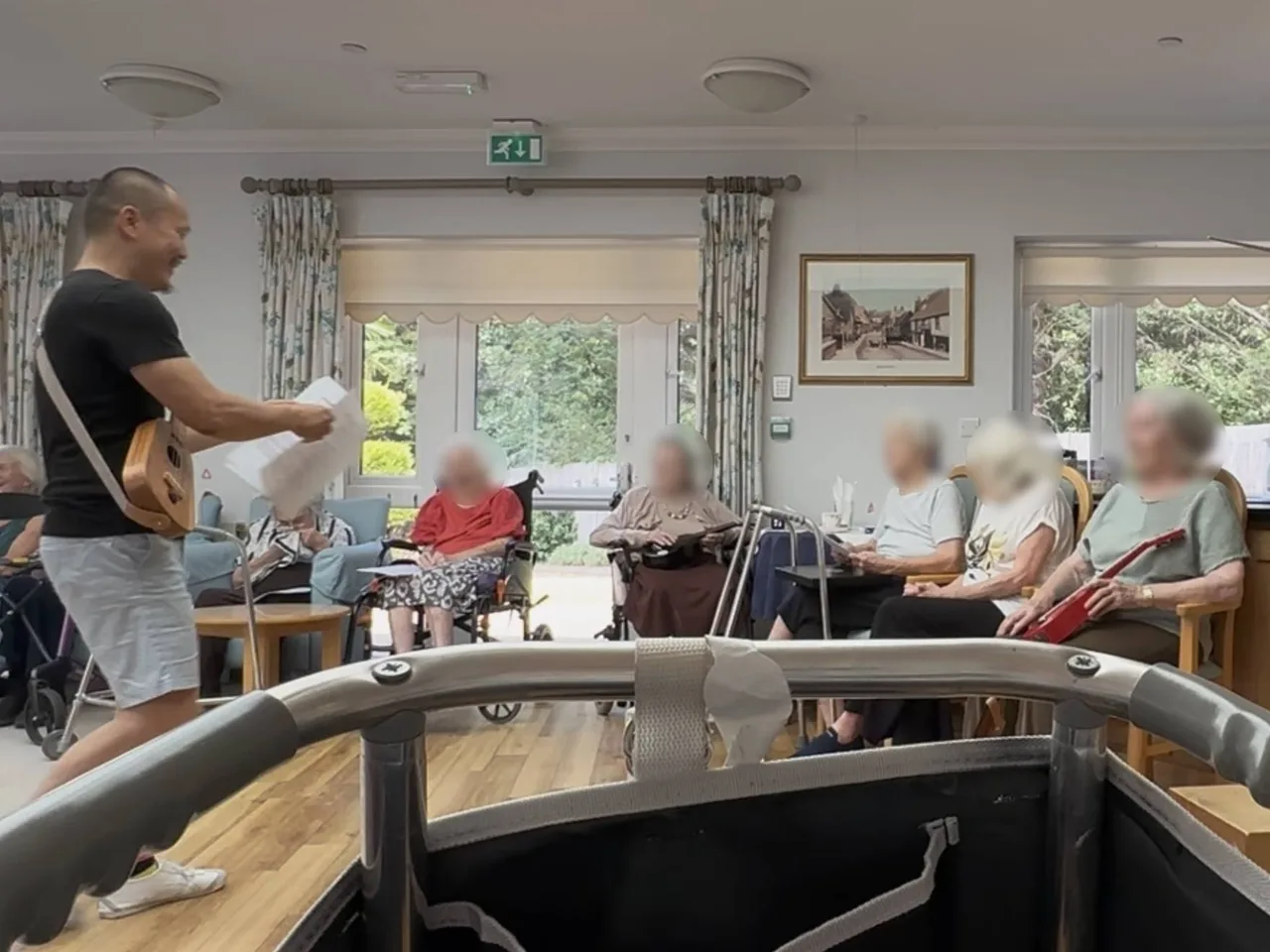 Elderly care home residents joining in a live ukulele music session — smiling and singing, active musical engagement, The Ministry of Happier