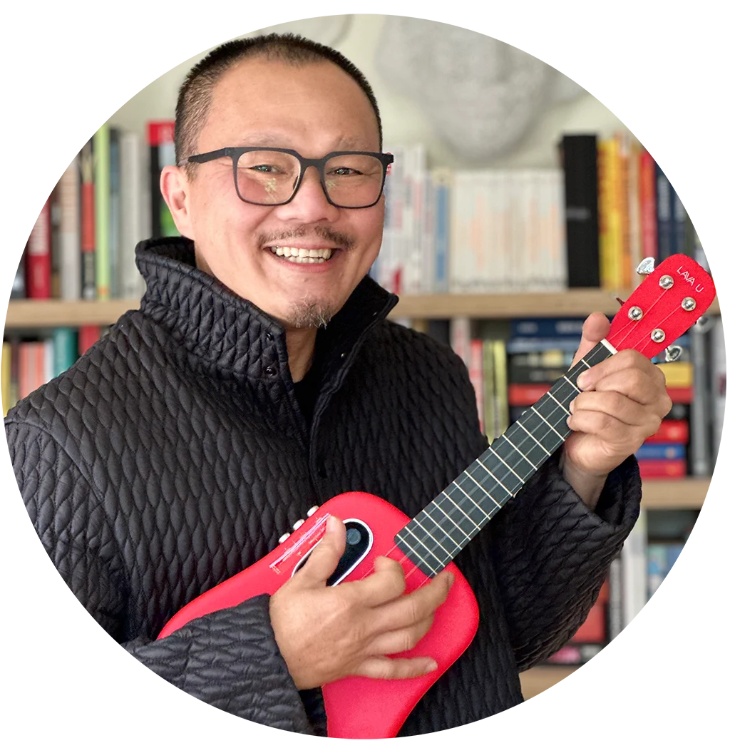 Frven Lim smiling and holding his red ukulele